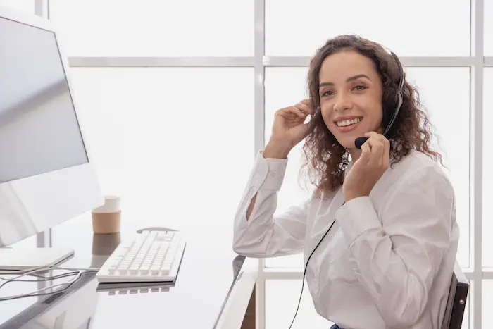 Eine Call-Center-Mitarbeiterin mit einem Headset vor einem Computer